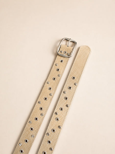 Cinturón de cuero beige extendido con herrajes plateados